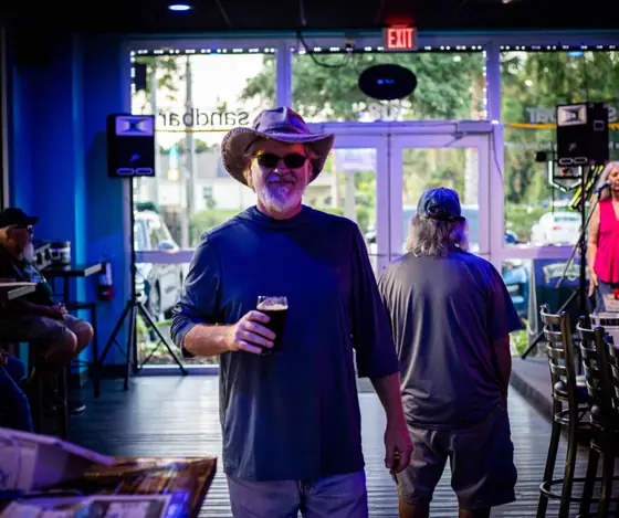 A guest in a cowboy hat holding a pint
