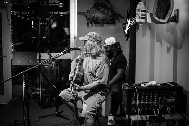 Black and white photo of two musicians mid-song