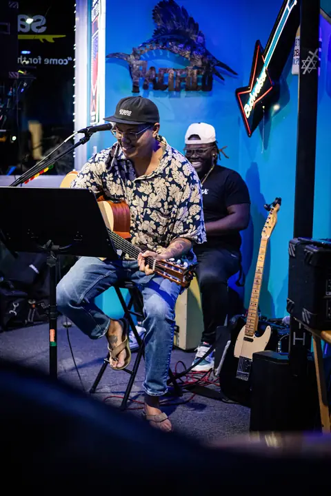 A guitarist and singer performing on the small stage