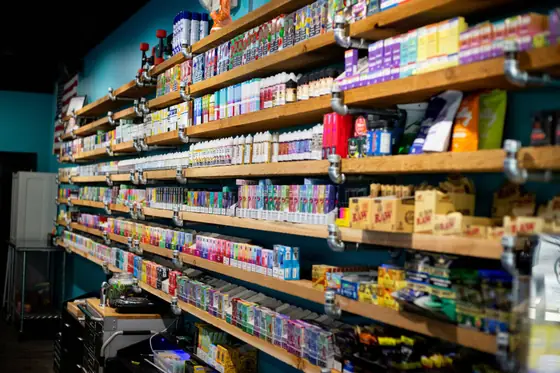 Long wall of stocked shelves in the Sandbar vape and smoke shop